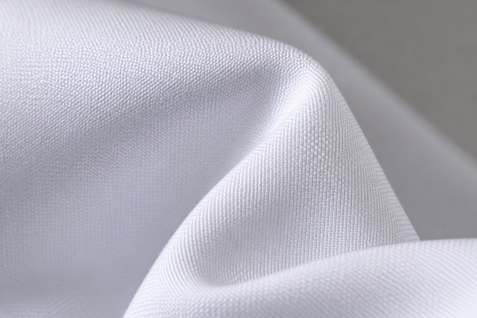 White doctor's lab coat fabric in a structured plain weave, shown alongside deep green OT wear fabric