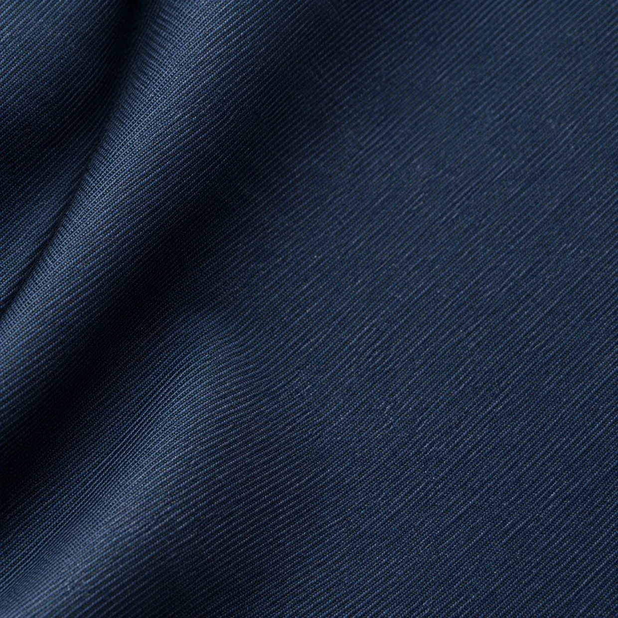 A macro view of navy poly-viscose suiting, the woven cloth that sits behind a fabric export figure