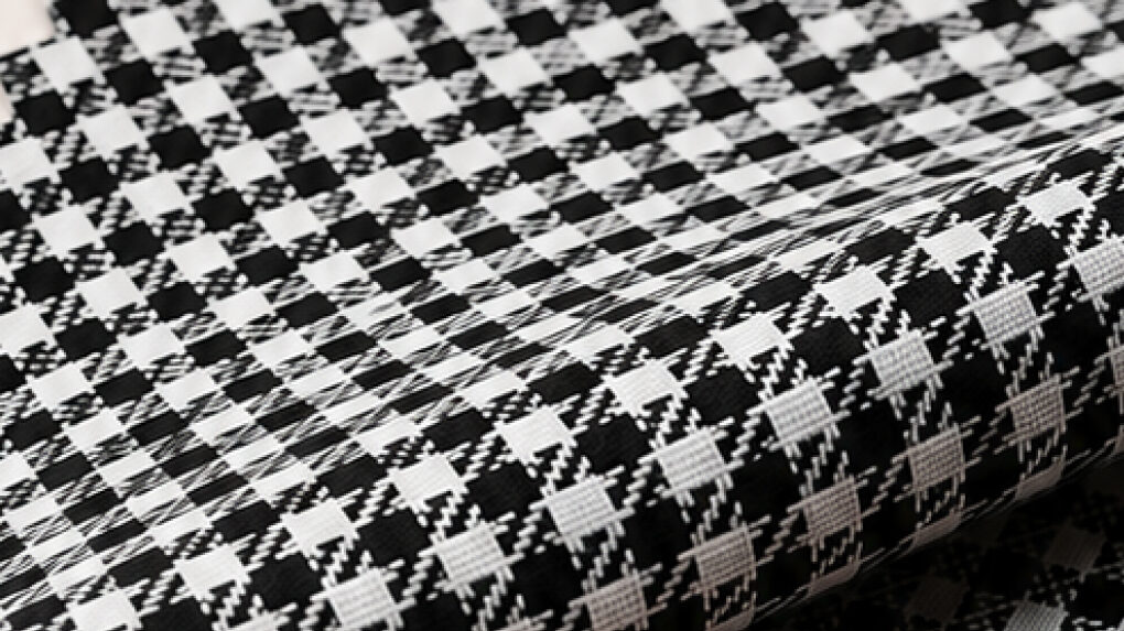 Black and white poly-viscose twill check blazer fabric folded to show the woven check and diagonal twill line